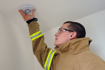 firefighter fitting a smoke alarm