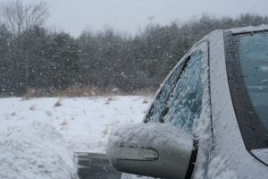 car covered in snow against a snowy road