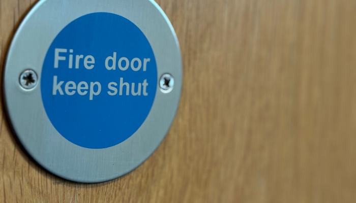 A picture of a sign on a door that says Fire door Keep shut