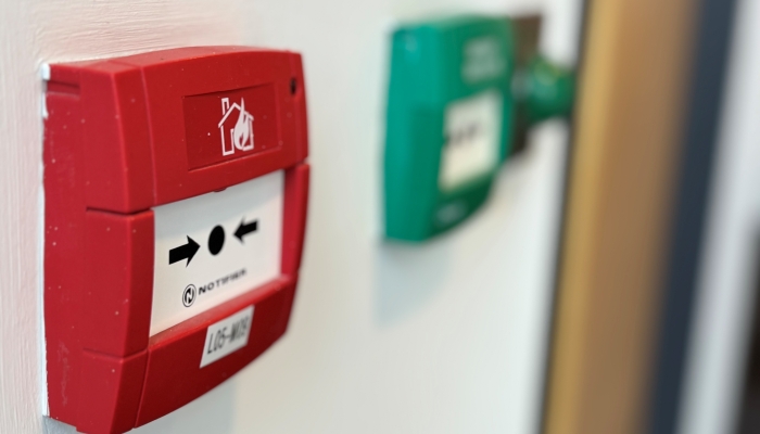 An image of a red fire alarm break point and green emergency release button 