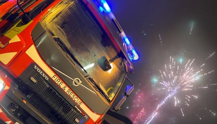 A fire engine next to a exploding firework 