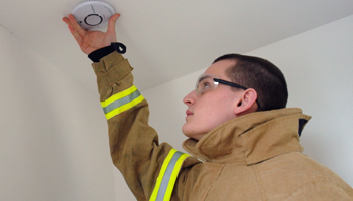 firefighter fitting a smoke alarm