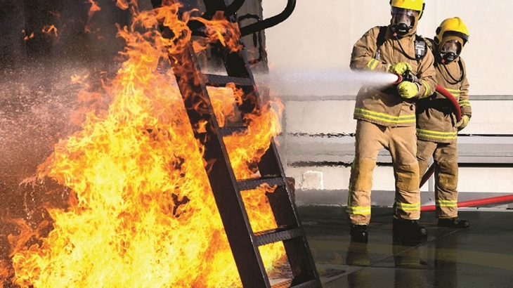 two firefighters fighting a fire on an offshore rig