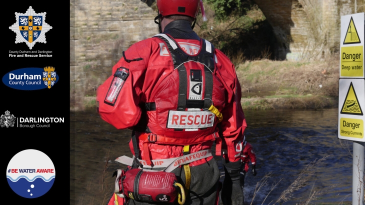 Firefighter standing looking out onto a river