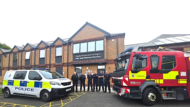Firefighters and PCSO's standing in a line outside of Consett Fire Station with police car and fire engine in the background. 