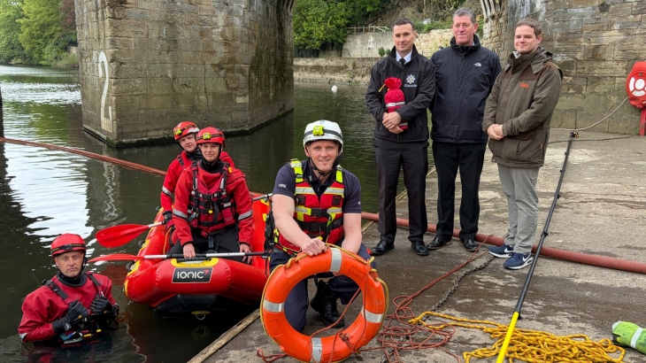 Durham firefighters wearing water rescue kit on riverside. 