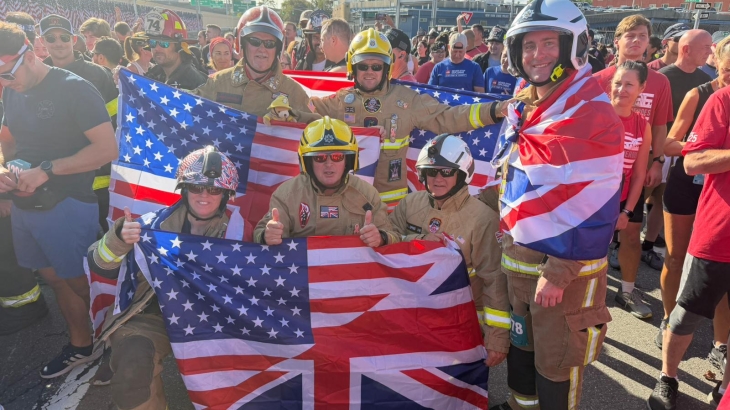 Firefighters wearing fire kit and holding flags at the start of the Tunnel to Towers race in New York. 