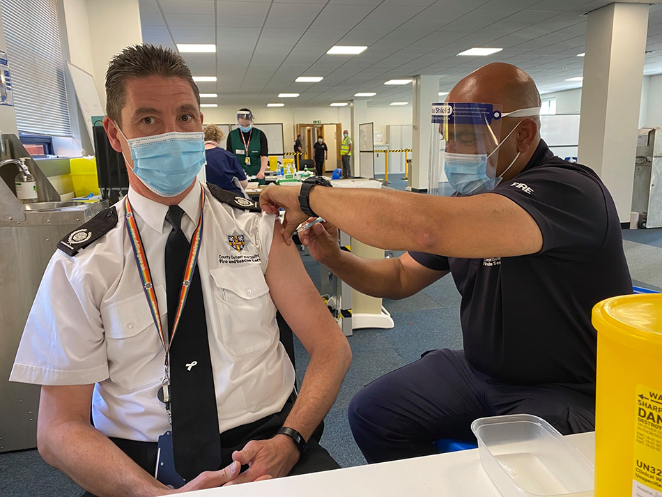 firefighter administering covid vaccine