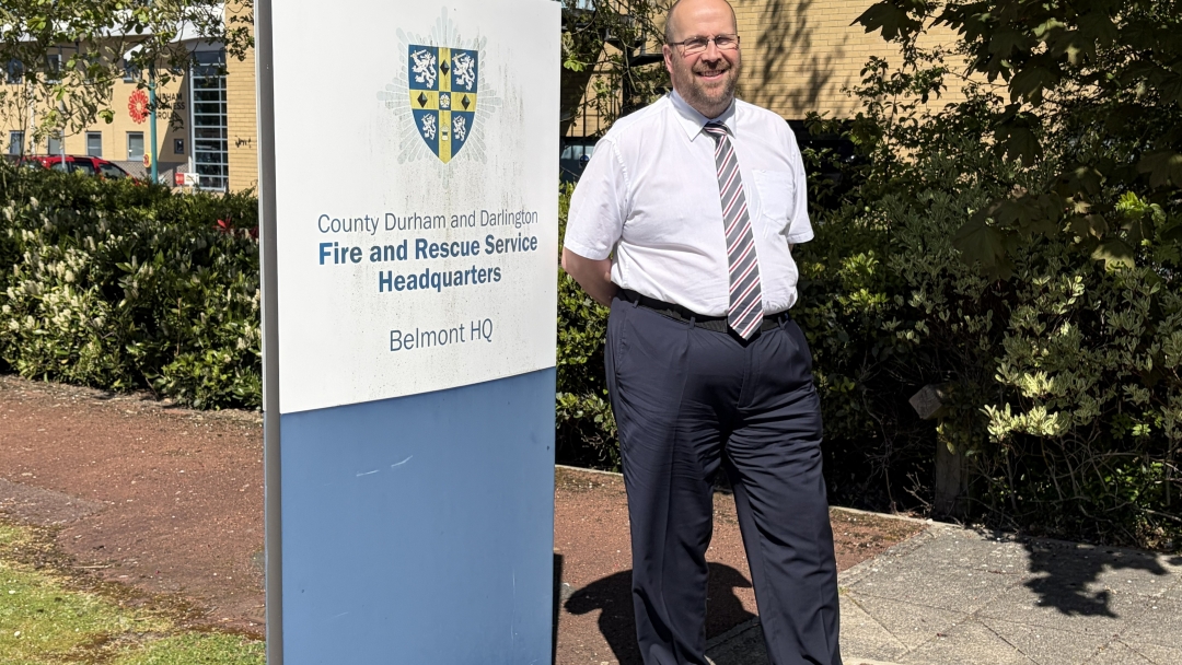 Health and Safety Advisor Jonothan Hitchen wearing Service uniform and standing by HQ sign. 