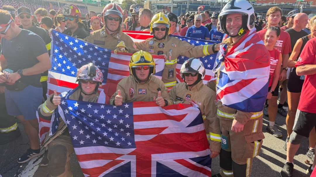 Firefighters wearing fire kit and holding flags at the start of the Tunnel to Towers race in New York. 